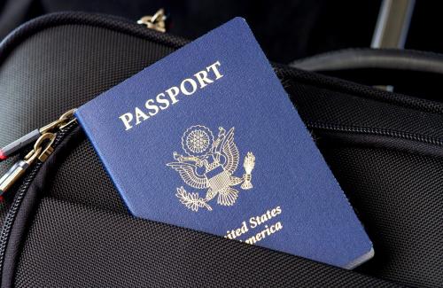 U.S. Passport inserted into the front pocket of a suitcase.