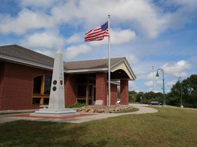 Library building with flag pole and the Exeter Veterans Monument